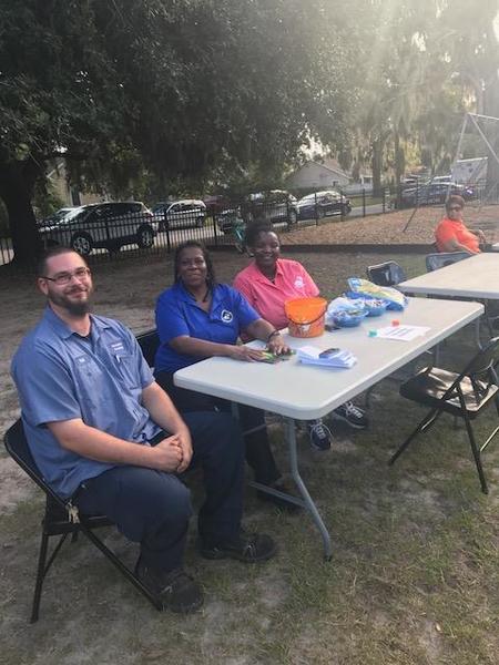 Beaufort Staff members participating in national night out with local law enforcement sitting at a table.